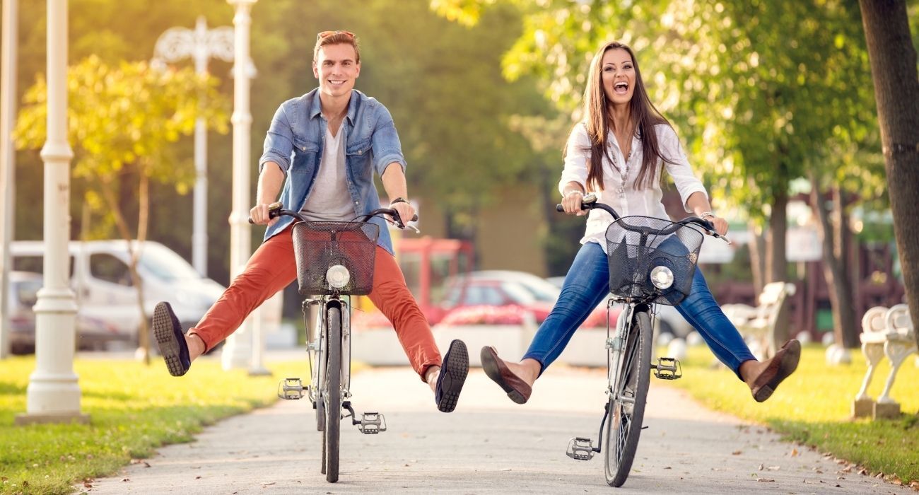 man and woman laughing riding bicycles