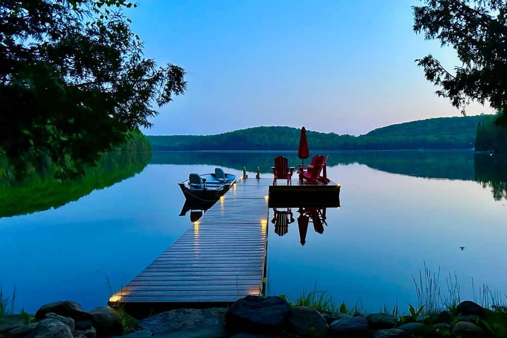 Getting Your Cottage Rental Ready for Spring - View of Ontario cottage rental waterfront with dock seating and watercraft