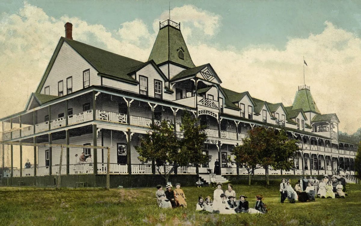 Historic picture of large inn and people sitting outside it, Windermere House in Muskoka